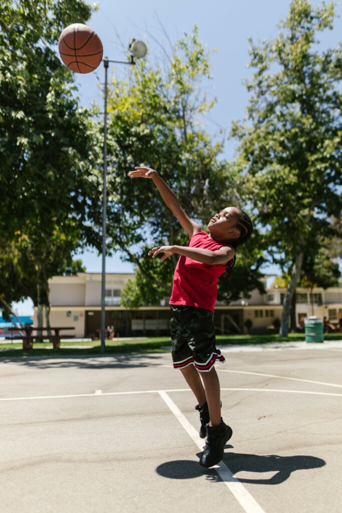Red Shirted Child Playing Basketball Child playing basketball in a red shirt to illustrate what is redshirting