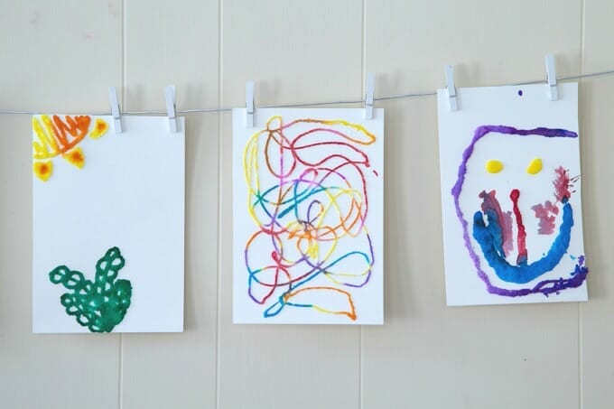 Raised Salt Watercolor Three paintings are hung from a clothes line in this example of kindergarten art projects.