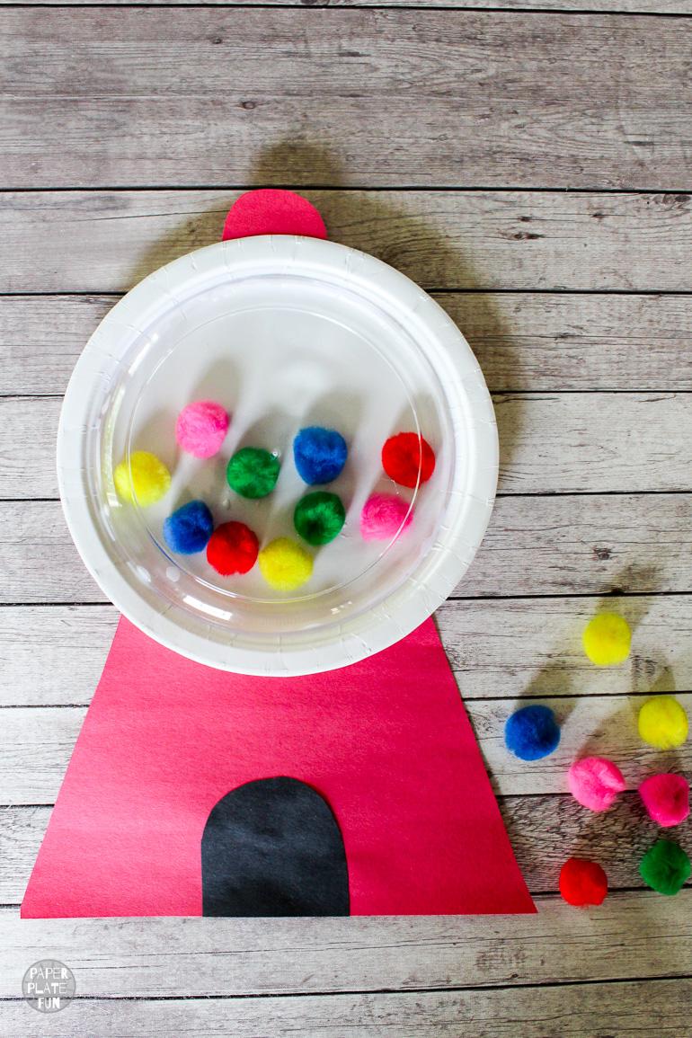 Gumball Machine Craft A white paper plate has different colored pom poms glued to it. Red cardstock completes the rest of the gumball machine