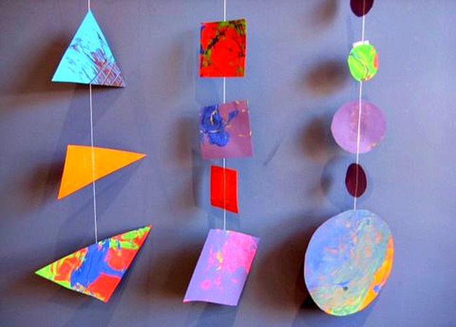 Kindergarten Art Shape Garland Colorful painted triangles, squares, and circles strung on garlands