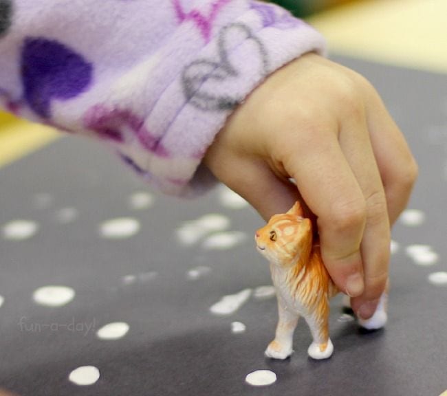 Kindergarten Art Fun a Day A child's hand is seen holding a small plastic cat.