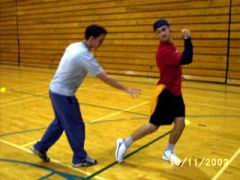 One player is seen running away with a pinnie hanging out of their shorts while another player tries to grab it in this example of tag games.