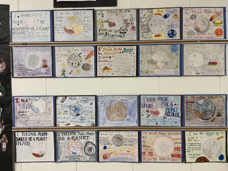 Pluto Posters Bulletin board featuring student designed posters about the planet Pluto.