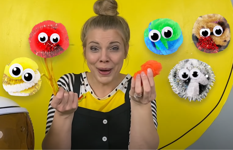 Pom Pom Planets Woman holding pom-pom planet crafts.