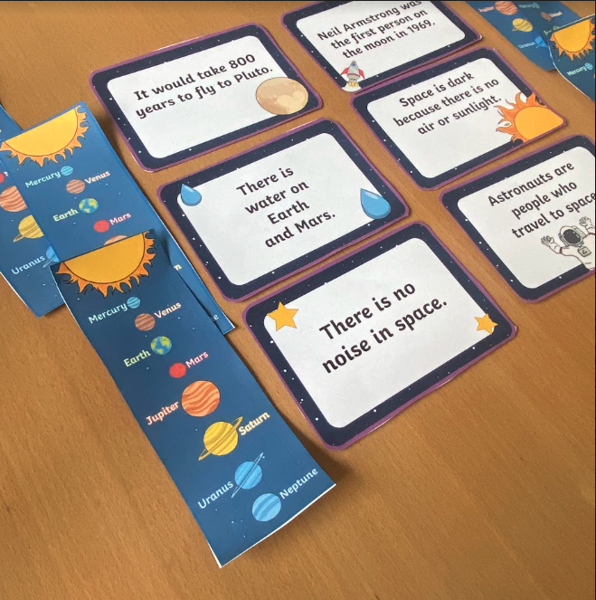 Solar System Fact Card and Bookmarks Printable solar system fact cards and bookmarks on a desk.