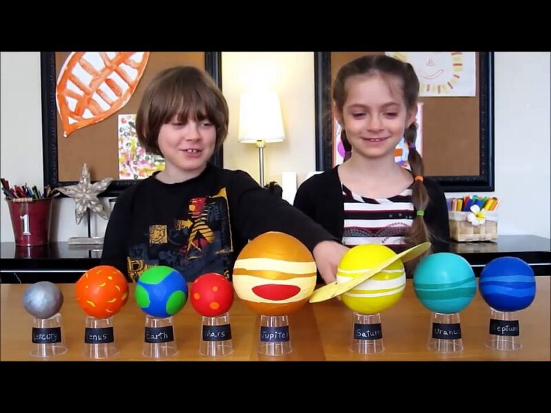 solarsystem4 A little boy and a little girl stand behind models of all of the planets (solar system projects)