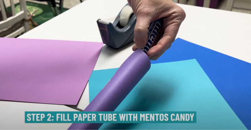 Mentos and Coke Experiment: Step 2 Teacher putting Mentos into a paper tube for the Mentos and Coke experiment.