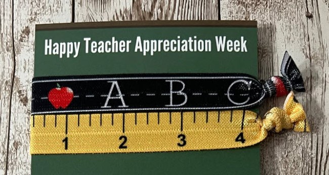 Two elastic hair ties, one with a chalkboard theme and one with a ruler theme, on a card that reads 