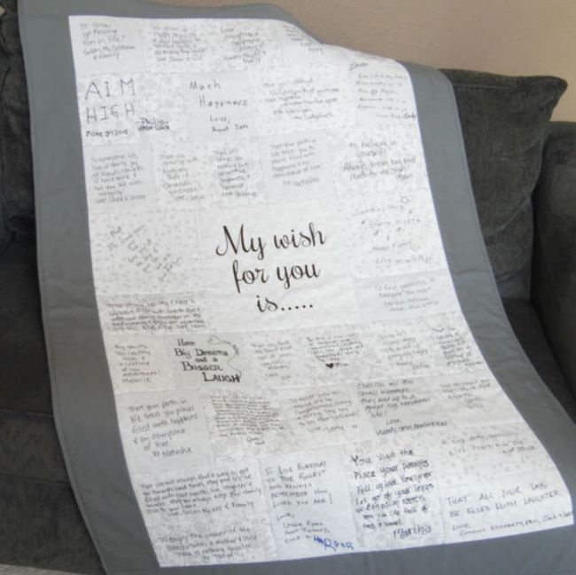 Gray-bordered quilt with autographs and messages on each square. Center square reads 