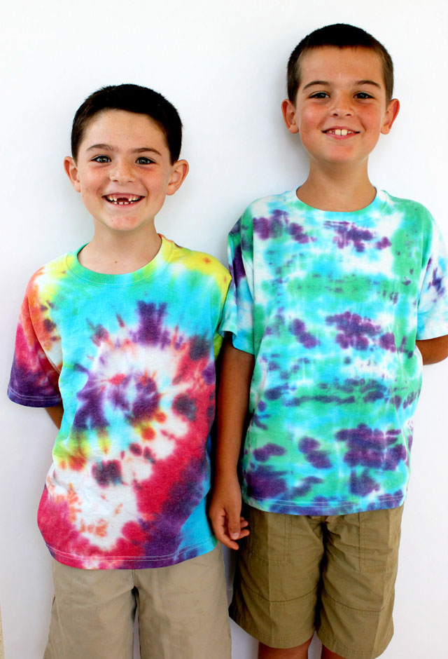 Two smiling boys wear colorful tie-dyed shirts