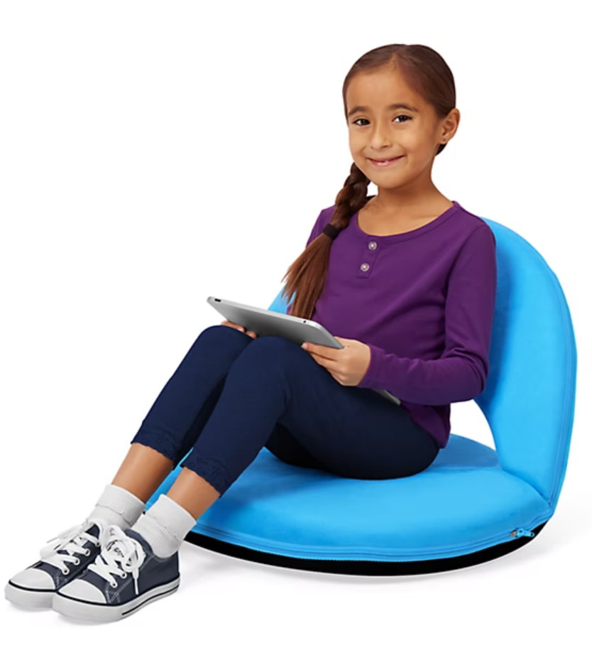 Young girl sitting in a floor chair holding a tablet