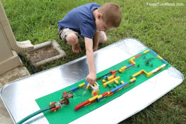 LEGO Watercourse Child playing with a watercourse built of LEGO bricks