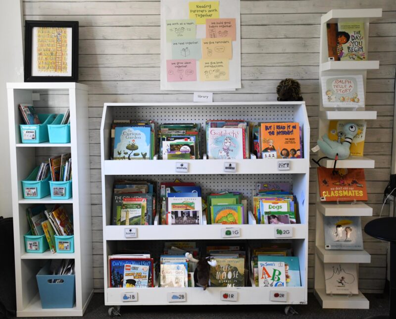 A book case is flanked by a cube storage and a set of wall shelves.