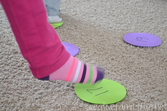 island-hop child's foot stepping on a number on the carpet for a math facts game