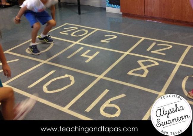 jump-on-facts numbers made of tape on the ground and a child jumping on them