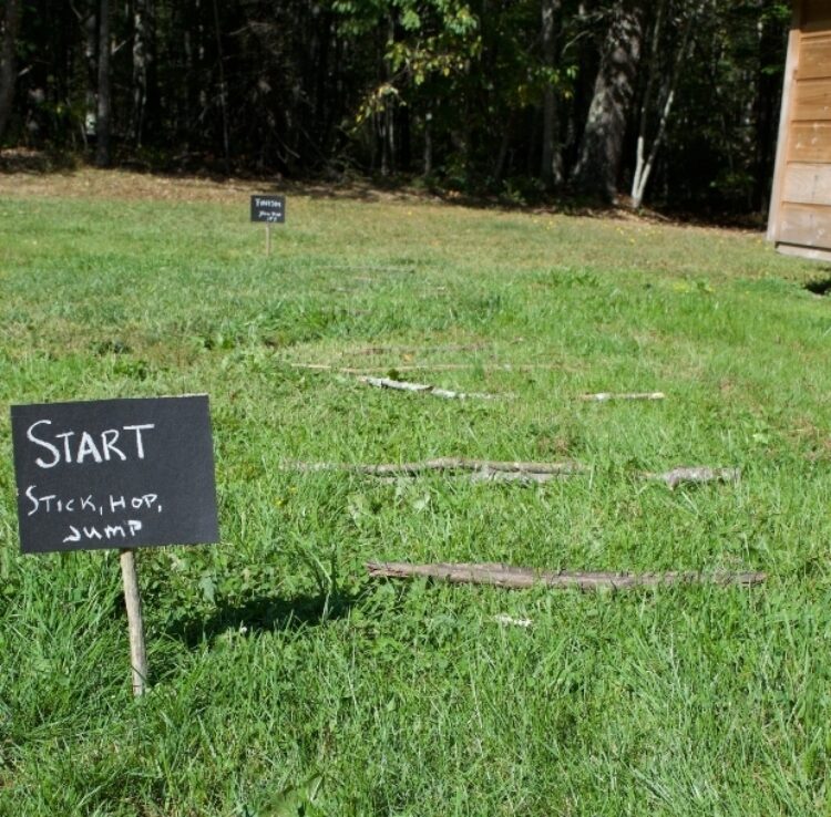 Nature_Obstacle_Course A grass lawn is shown with a small chalkboard that says