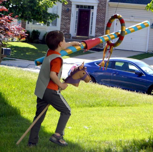 DIY Obstacle Courses for Kids: Jousting A child riding a hobby horse and stick a cardboard tube through a hoop