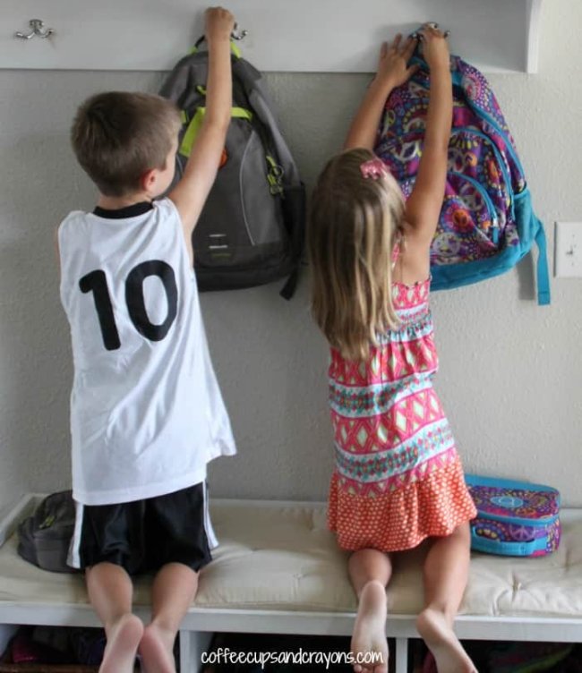DIY Obstacle Courses for Kids: School Skills Two children hanging up their backpacks on hooks on the wall