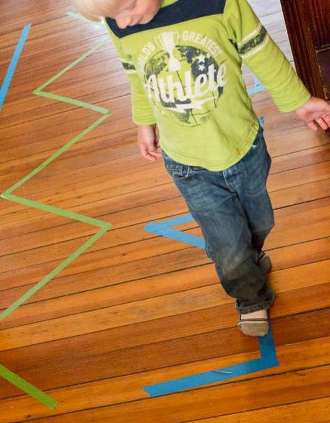 DIY Obstacle Courses for Kids: Tape Toddler walking along a masking tape line on a floor