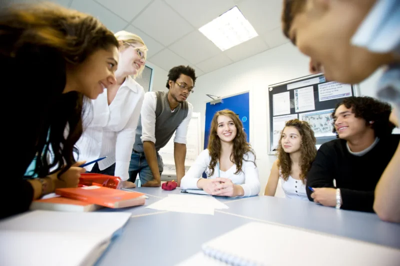 iStock-157309156_master Teens gathered around a table, talking and smiling