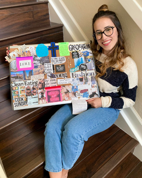teen-vision-board A proud teenage girls sits on a staircase displaying her vision board