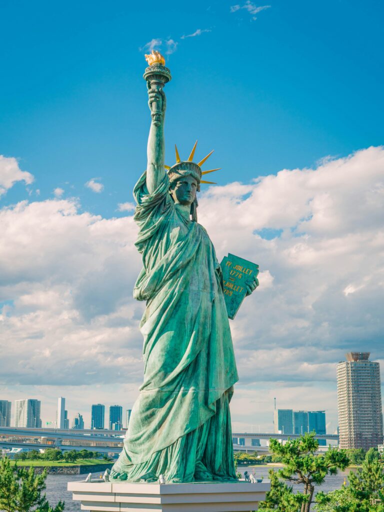 Statue of Liberty with skyscrapers and sky in the background