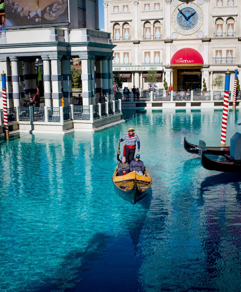 Man steering a gondola in Venetian costume in a pool