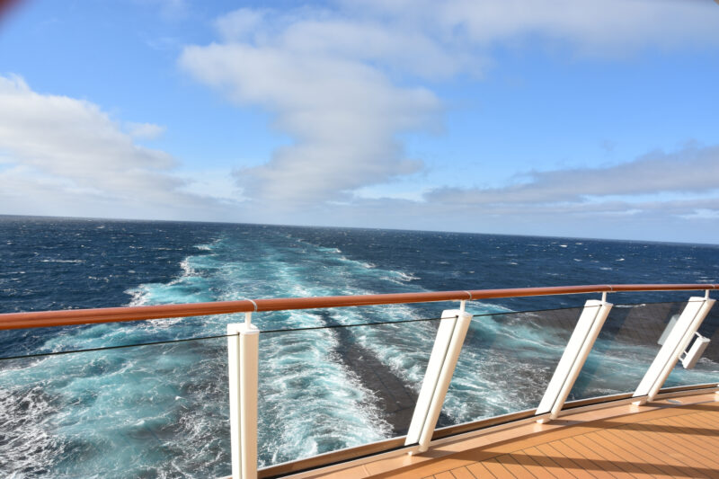 View from the back of a cruise of the ocean with water trail down the middle