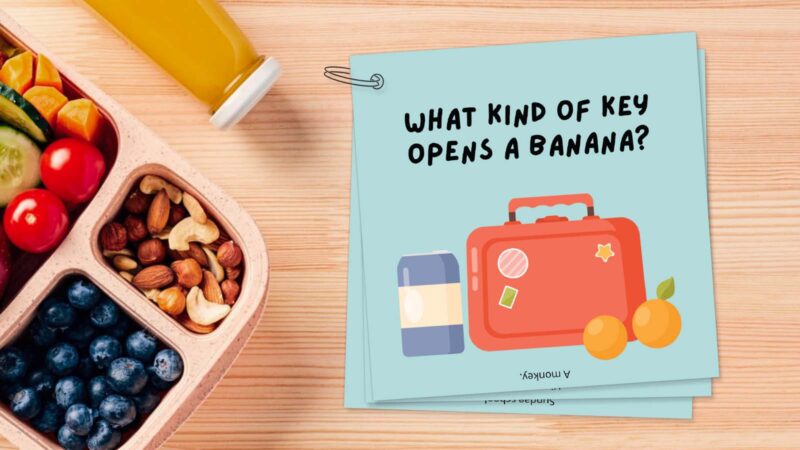 Bento box on table with a keyring featuring lunch box jokes, such as What kind of key opens a banana? 