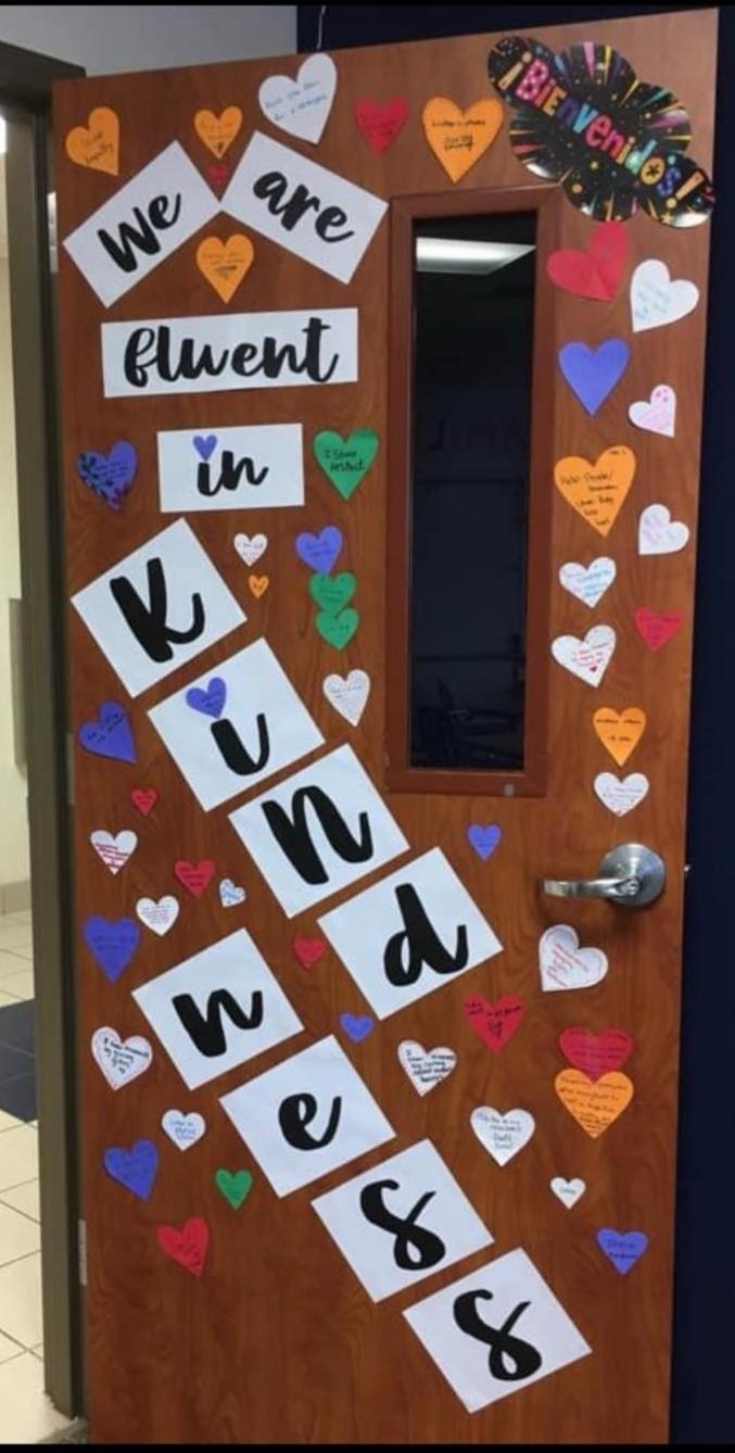 A door says we are fluent in kindness and features hearts all over.