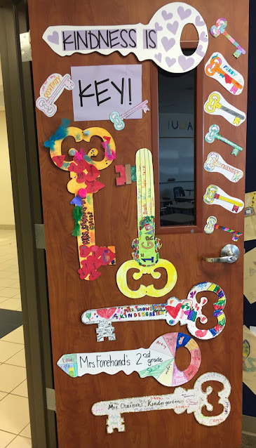 A door says Kindness is key and features several keys of varying sizes and colors.