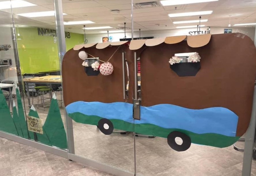 Two double door glass doors are decorated to look like a camper. 