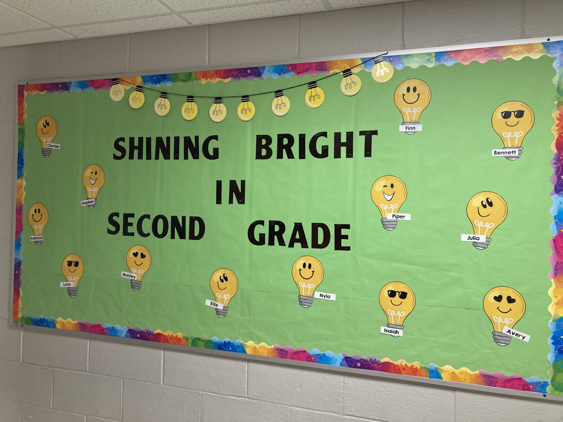 Shine-Bright Little light bulbs with student names on them are featured. Bulletin board says Shining Bright in Second Grade.