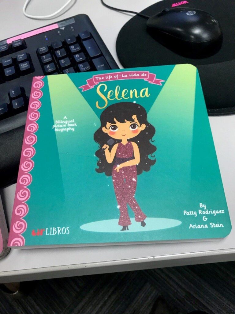 Selena board book on top of computer keyboard.