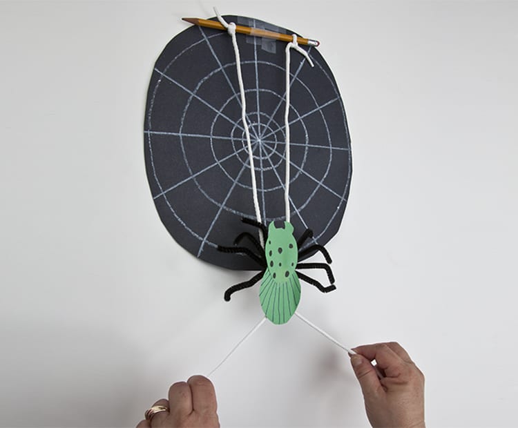 climbing-spider A halloween paper craft of a black spider web and a green spider