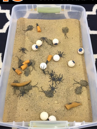 dig-for-witch-fingers-3 A plastic bin filled with sand and plastic halloween toys