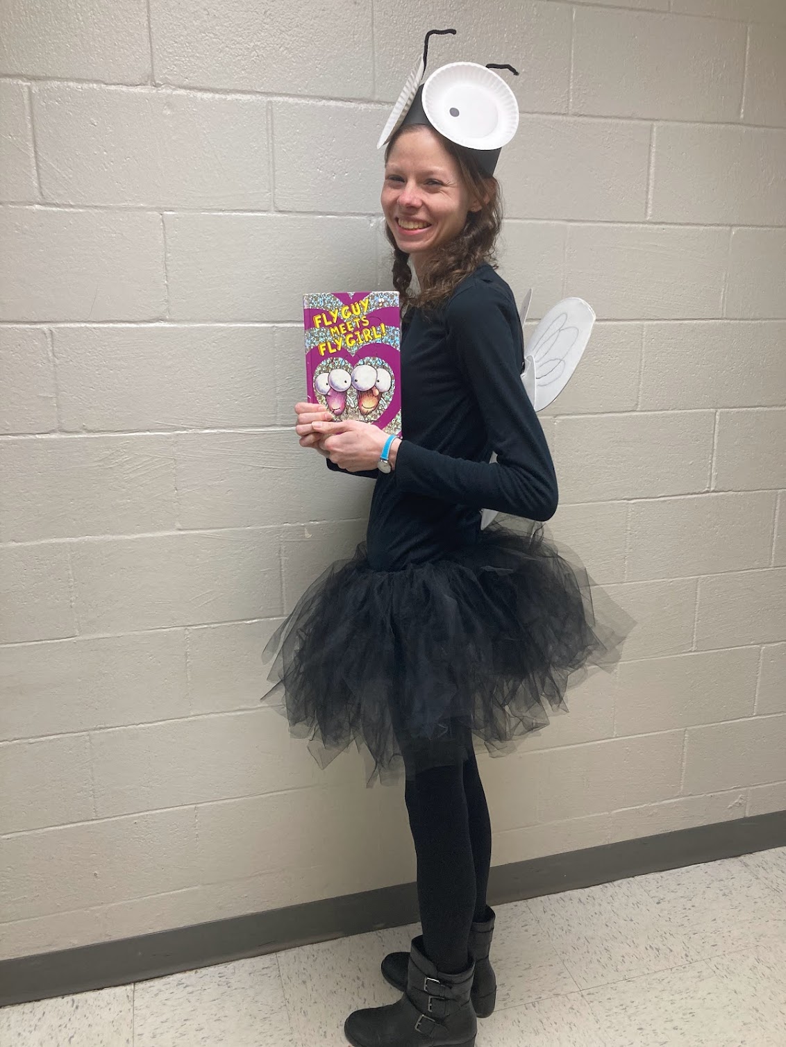 Halloween Costumes: Fly Guy Teacher dressed as Fly Guy and holding the picture book