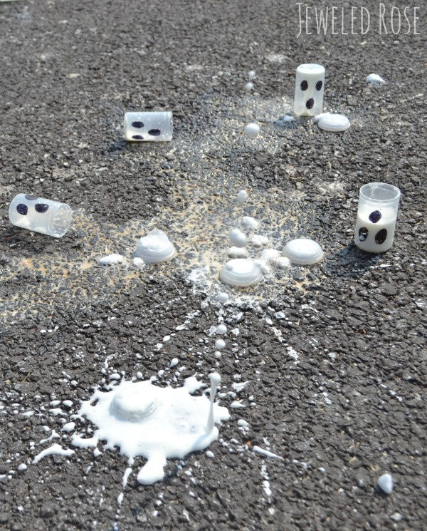 ghost-rockets Film canisters with black eyes drawn on laying on the pavement with spilled white liquid around them