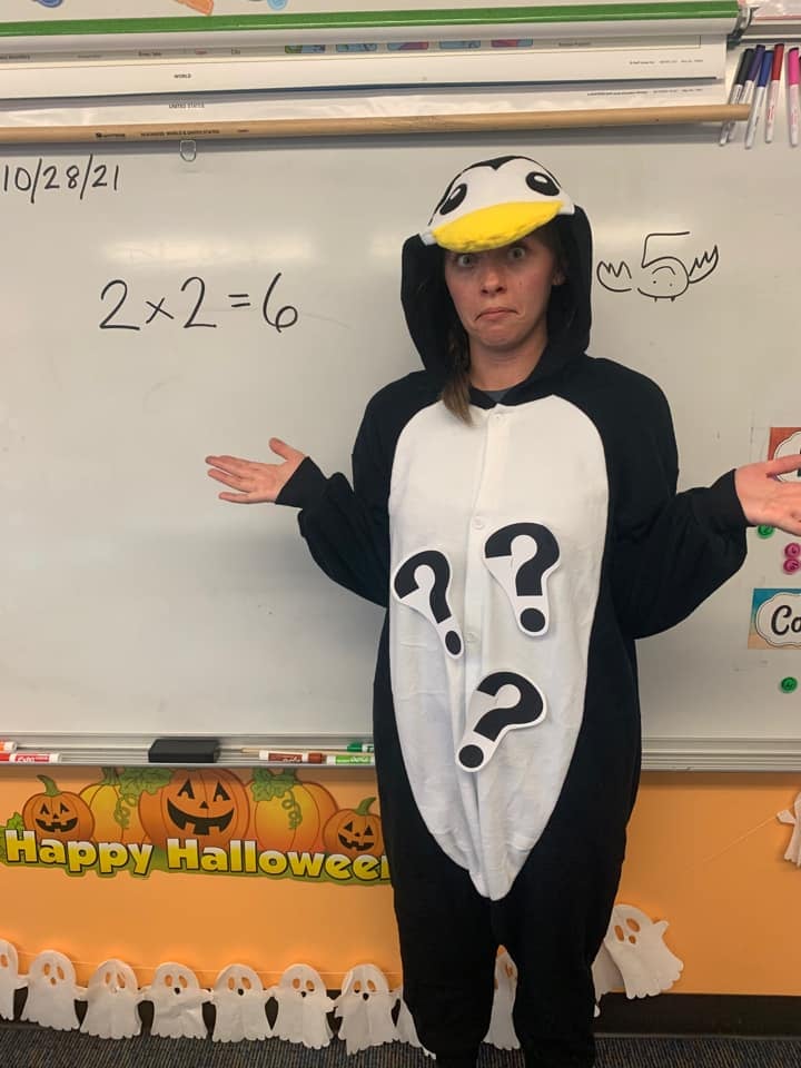 Halloween Costume: ;Puzzled Penguin Teacher wearing a penguin costume with question marks attached