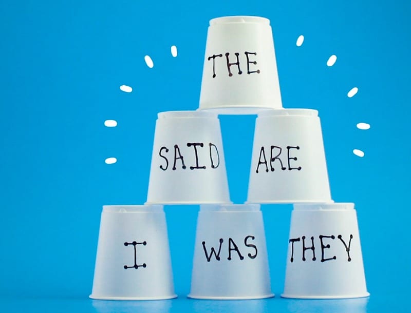 cups with words written on them in a stack for sight word activity 