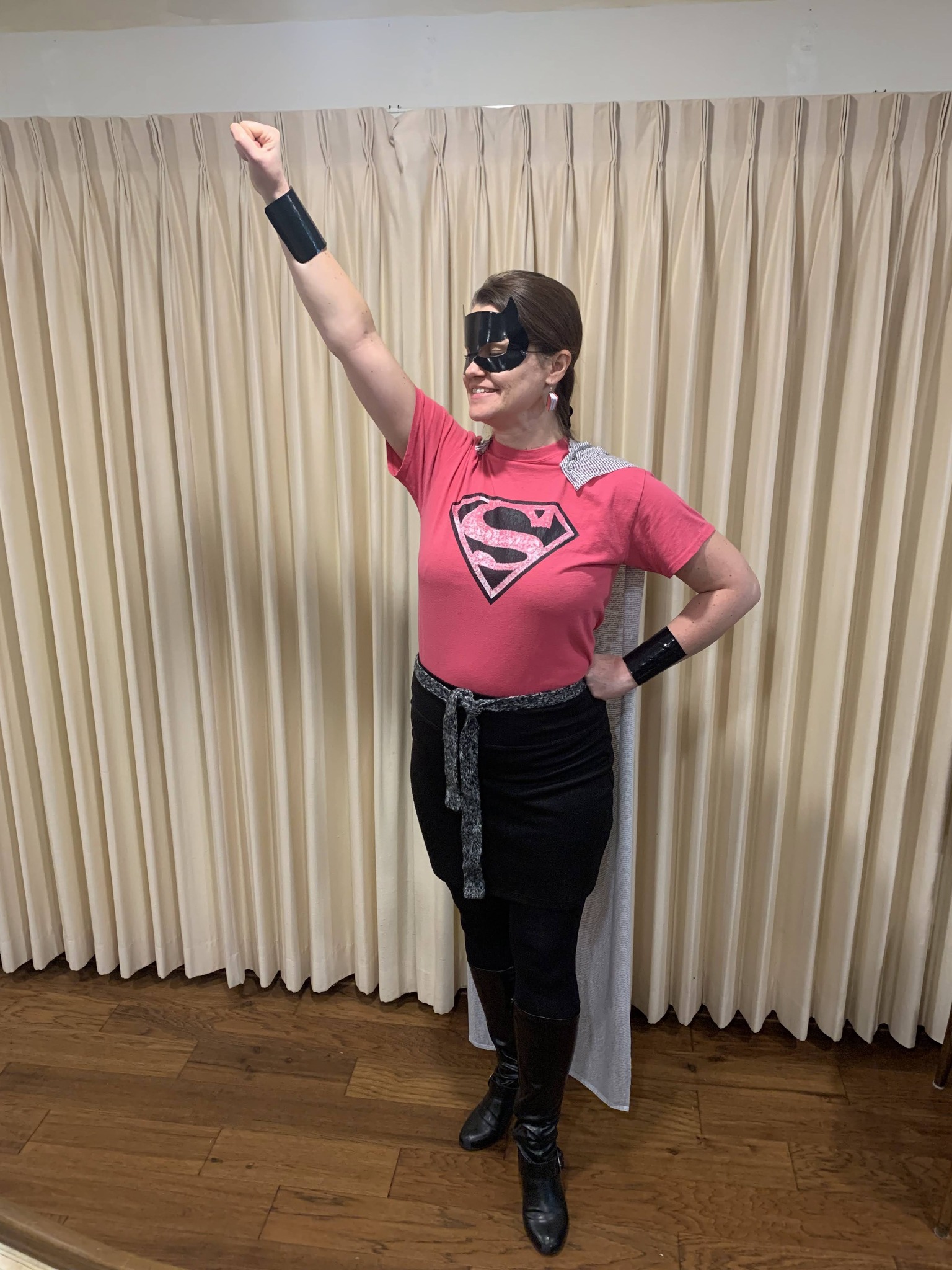 Halloween Costumes: Super Reader Teacher dressed as Super Reader, wearing a cape made of material that looks like book pages