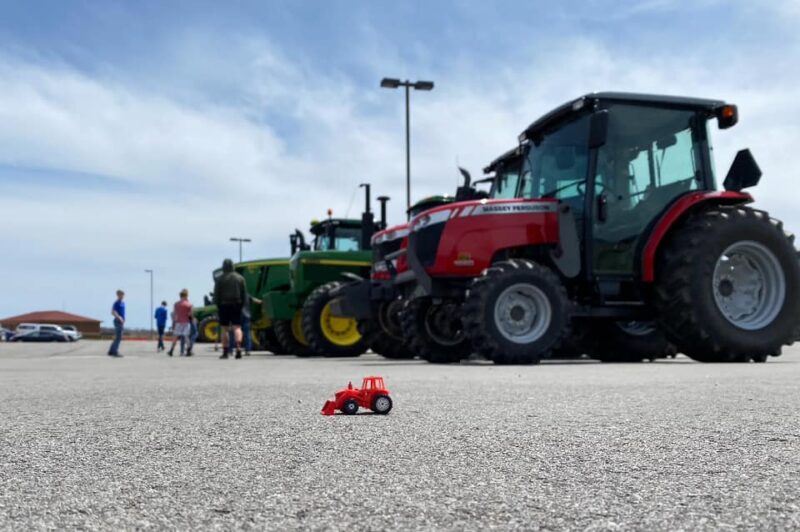 tractor Tractors in a parking lot with a small tractor in front