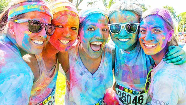 color-run Five girls with multi-colored faces gather after a color run