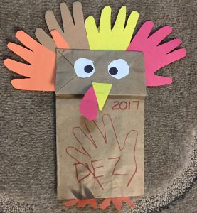 handprint-turkey-puppet A paper bag puppet made to look like a turkey with paper cutout handprints as feathers