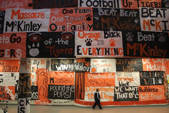 spirit-posters A student walks by a wall covered with black and orange spirit posters