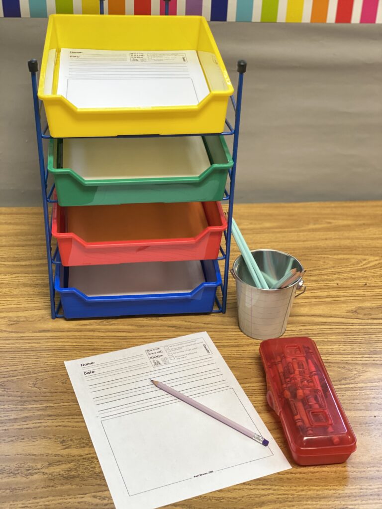 Writing Area Writing area with colored bins in a kindergarten classroom.