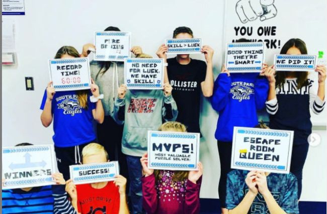 Classroom Escape Room Students celebrating the completion of an escape room by holding up signs