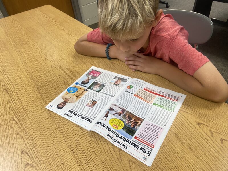 TWJ Image1 (1) blonde white boy reading The week Junior Big Debate section