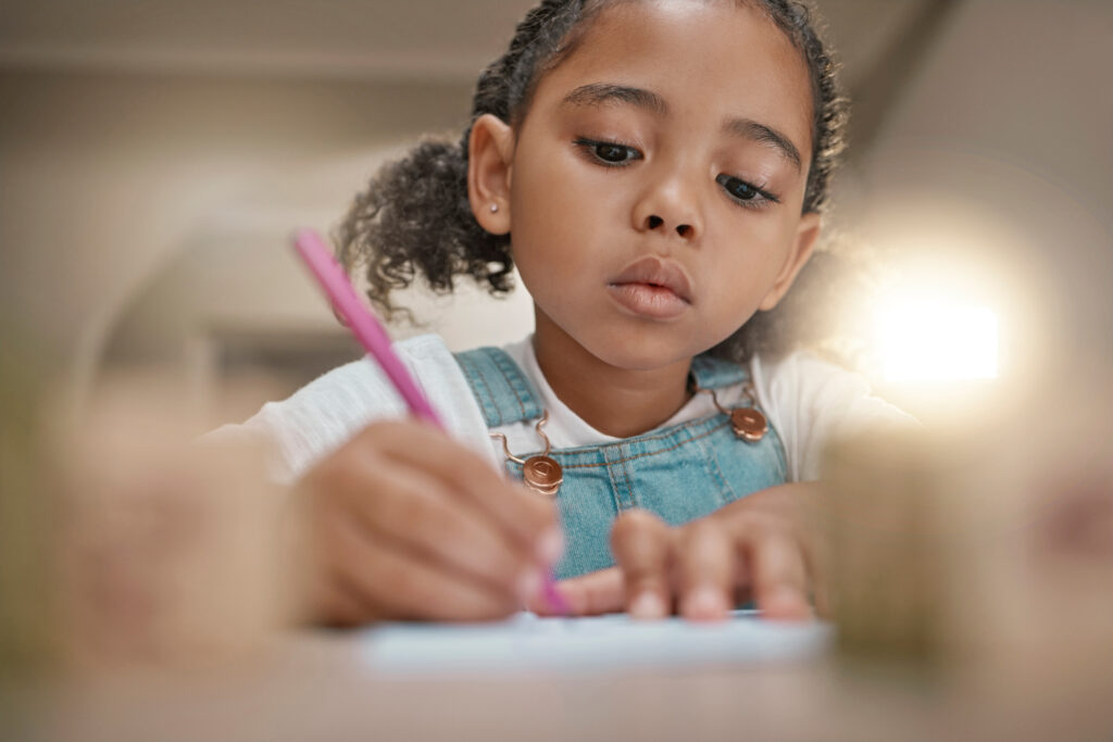 Student, child learning and writing in notebook for development, fine motor skills and home schooling. Education, knowledge study and kid creative drawing or write on paper with pencil on home desk