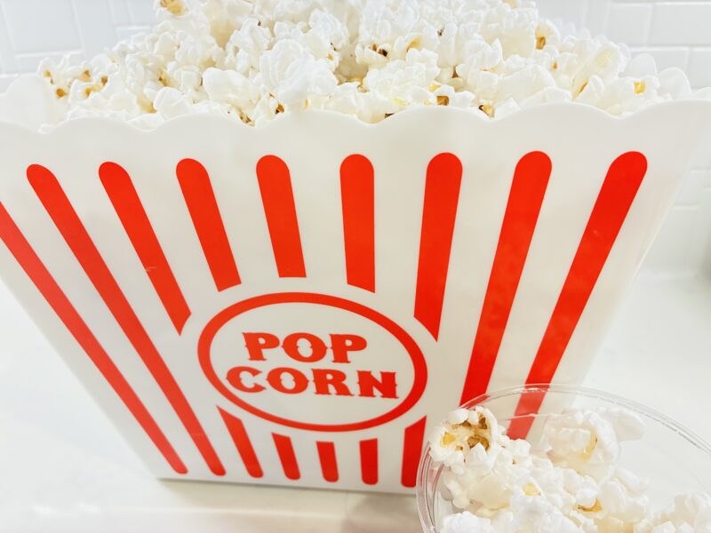 a photo of popcorn in a red and white stripped bucket
